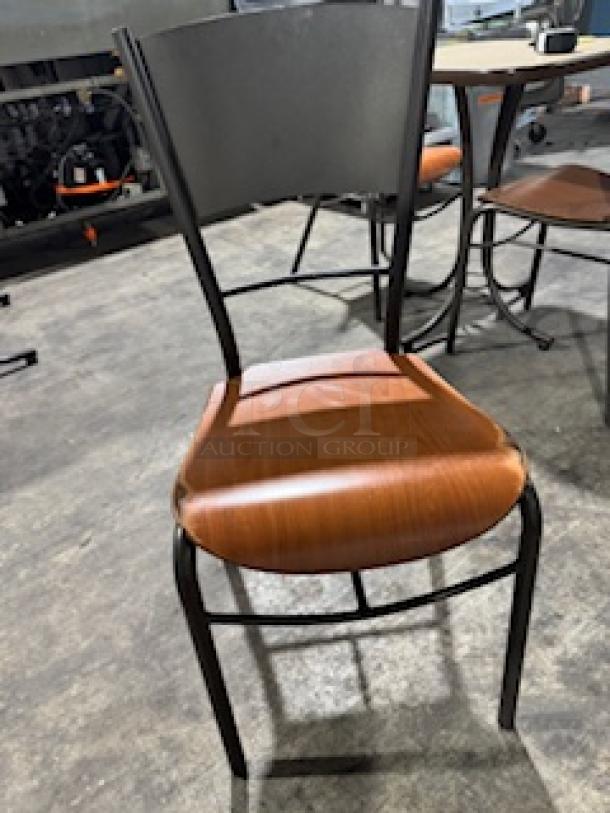 Modern dining chair with bronze base, wooden seat, and metal backrest. Excellent condition. Sleek design.