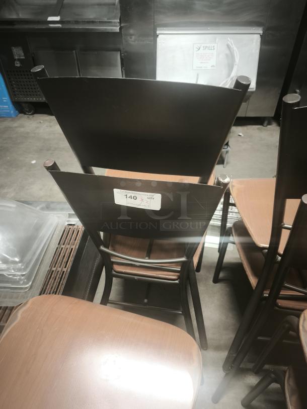 Set of dining chairs with bronze base, wooden seats, metal backrest. Visible label with quantity marker. Good condition.