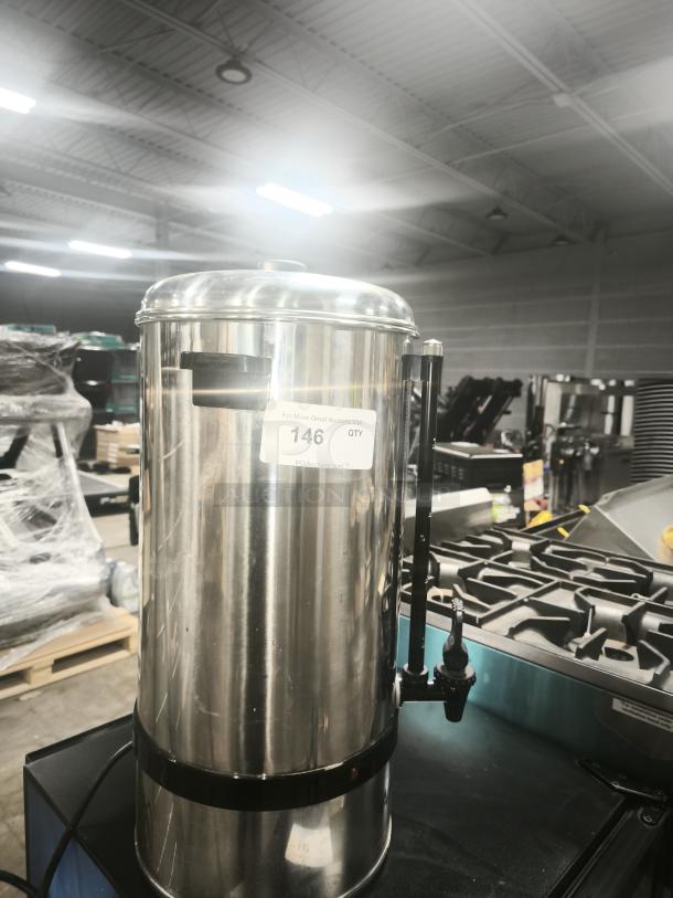 Adcraft CW-100 100-Cup Stainless Steel Coffee Urn, polished finish, sturdy base, visible spigot, tag with auction info.