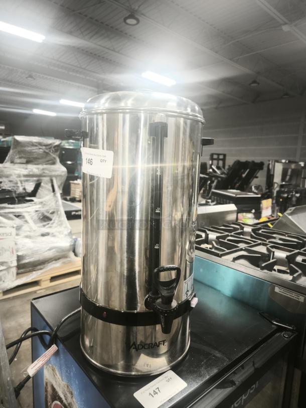 Adcraft CW-100 stainless steel coffee urn, 100-cup capacity, side handles, visible water level gauge, tag shows item "146 QTY".