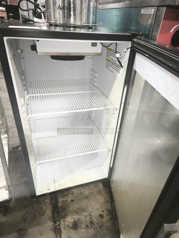 QBD Pepsi single-door glass merchandiser cooler in used condition, two shelves, visible caution labels inside.