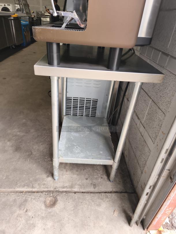 Regency 30" x 36" stainless steel work table with undershelf, visible wear, ideal for commercial use.