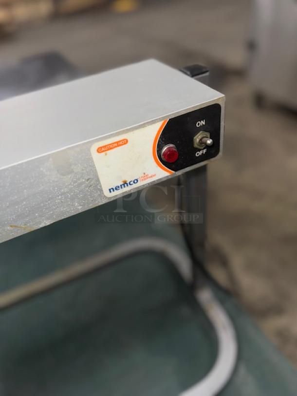 Nemco 6152-24 single rod strip warmer with fixed arm, built-in toggle switch, and "Caution Hot" label, in tested condition.