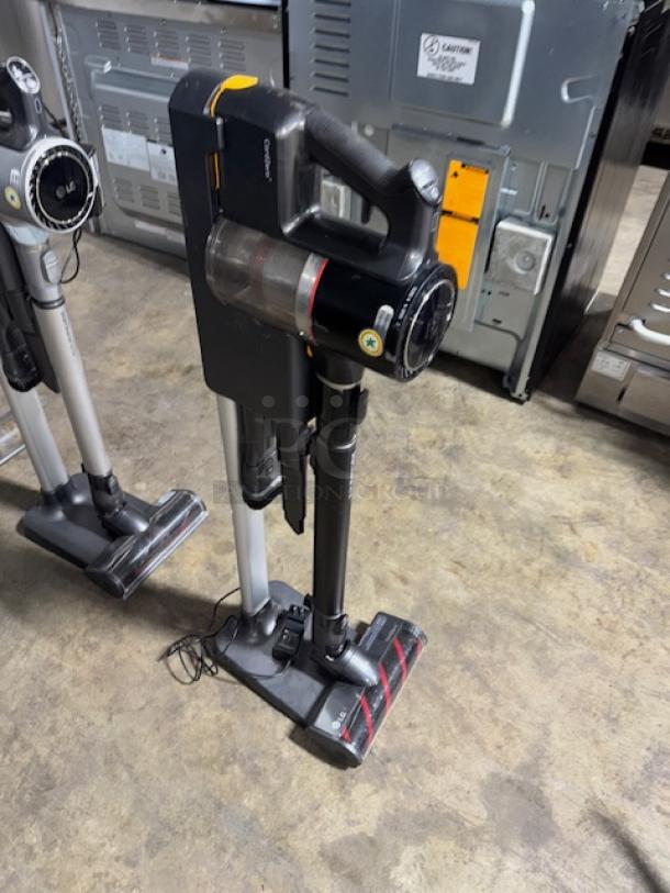 LG CordZero A9 Cordless Stick Vacuum, black, tested and working, with charging stand. Visible LG logo and control buttons.