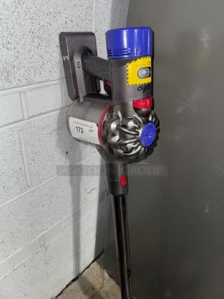 Dyson V11 Torque Drive+ Cordless Vacuum, mounted on wall, features blue and yellow accents, excellent condition.