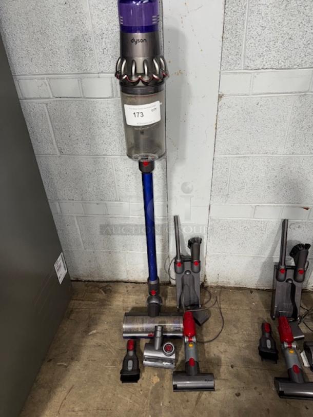 Dyson V11 Torque Drive+ Cordless Vacuum Cleaner, includes multiple attachments. Slightly used condition. Auction tag visible.