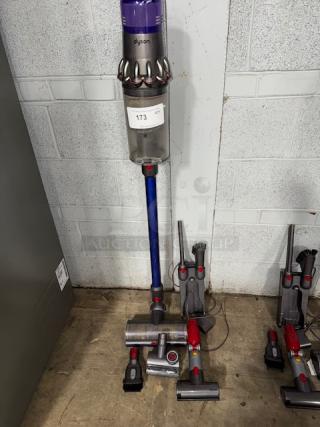 Dyson V11 Torque Drive+ Cordless Vacuum Cleaner, includes multiple attachments. Slightly used condition. Auction tag visible.