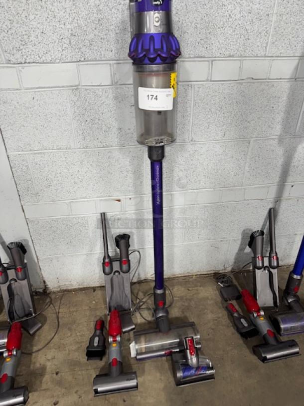 Dyson V11 Torque Drive Cordless Vacuum Cleaner, purple, with attachments. Good condition. Auction tag 174 visible.