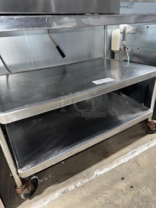 Stainless steel service cart, 3 shelves, 31x19x33 inches. Features durable construction and wheels for mobility. Used condition.