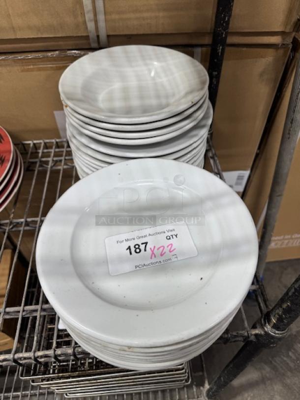 Bright white wide rim rolled edge stoneware plate stack, gently used. Auction tag indicates lot number and quantity.