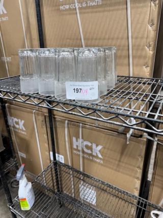 Set of Cambro LT22152 Laguna 22 oz. clear glasses on metal shelf; condition appears unused.