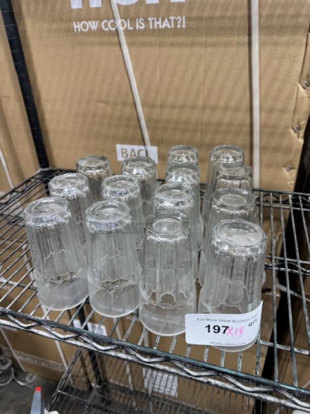 Cambro LT22152 Laguna 22 oz. clear glasses on a shelf, in excellent condition. Marking visible with auction lot number.