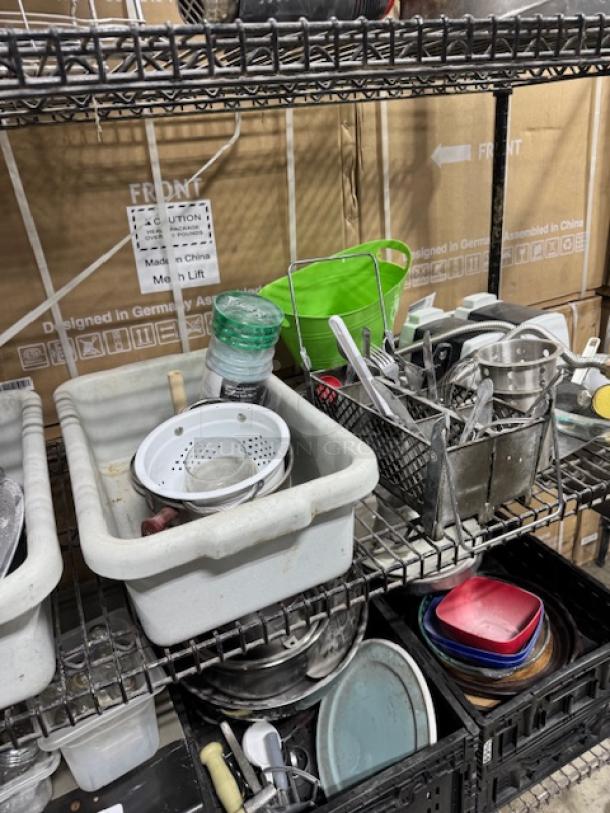 Kitchenware assortment on metal shelves, includes colander, utensils, bowls, and containers. Varied condition, one price.