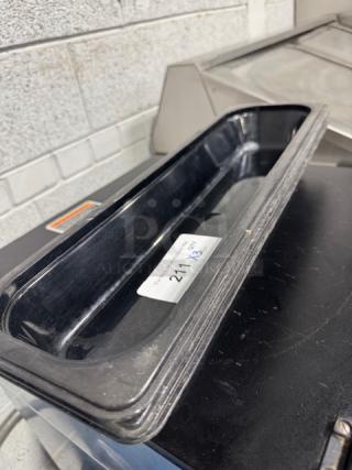 Polycarbonate 1/9-size food pan, black, in good condition. Label visible inside, used for storage or food service.