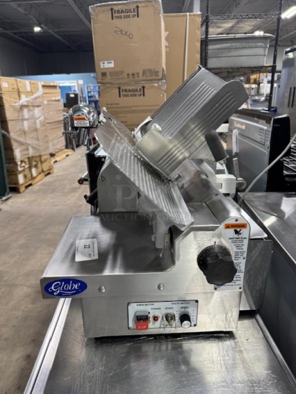 Globe 3875V 12" commercial meat slicer in good condition, tested and working. Features adjustable thickness dial and power controls.