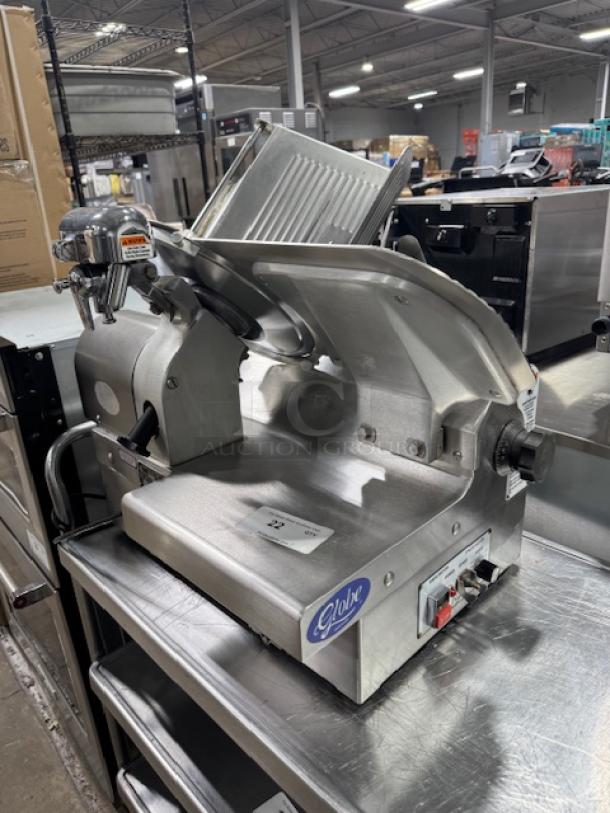 Globe 3875V 12" commercial meat slicer, tested, working, good condition. Stainless steel, adjustable slicing thickness, power controls visible.
