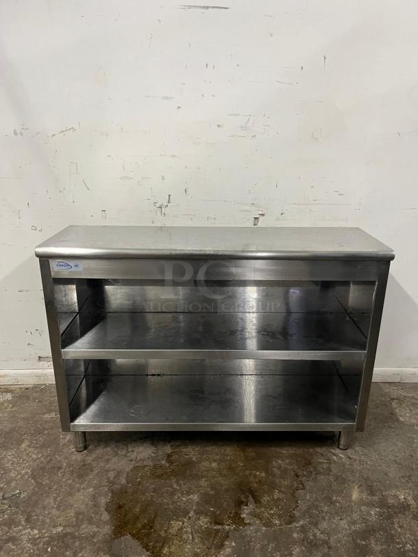 Stainless steel open-front cabinet by Yukon, featuring two shelves. Good condition, suitable for storage or display.