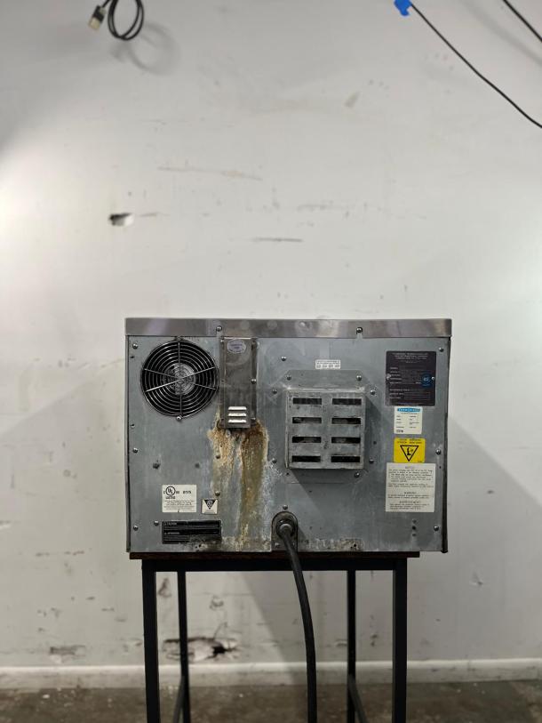 TurboChef NGC commercial ventless high-speed oven. Visible wear and rust on metal surface. Tags show model and safety warnings.