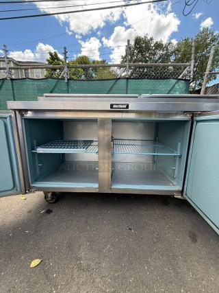 Delfield 18672PTLP 72" two-door refrigerated pizza prep table with raised rail, open doors, and shelves shown.