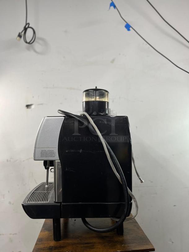 La Cimbali M2 BARSYSTEM commercial espresso machine, black and silver, fully automatic, slight visible wear, side view.