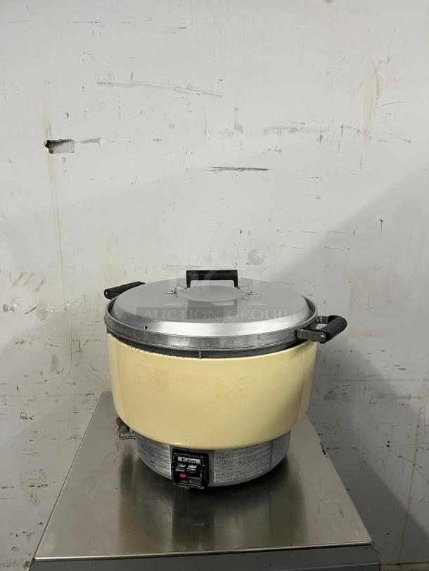 Rinnai RER55ASN 55-cup commercial natural gas rice cooker, featuring stainless steel lid and handles; visible wear on exterior.