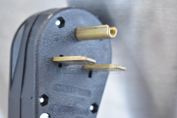 Close-up of a power plug for AM Manufacturing LT1800BH Hot Pizza Press. Features metal prongs, suitable for 208V, 3-phase.