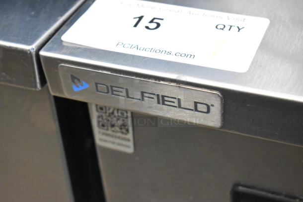 2020 Delfield 406P-STAR2 stainless steel single door cooler, visible Delfield logo. Tags show auction info, commercial casters.