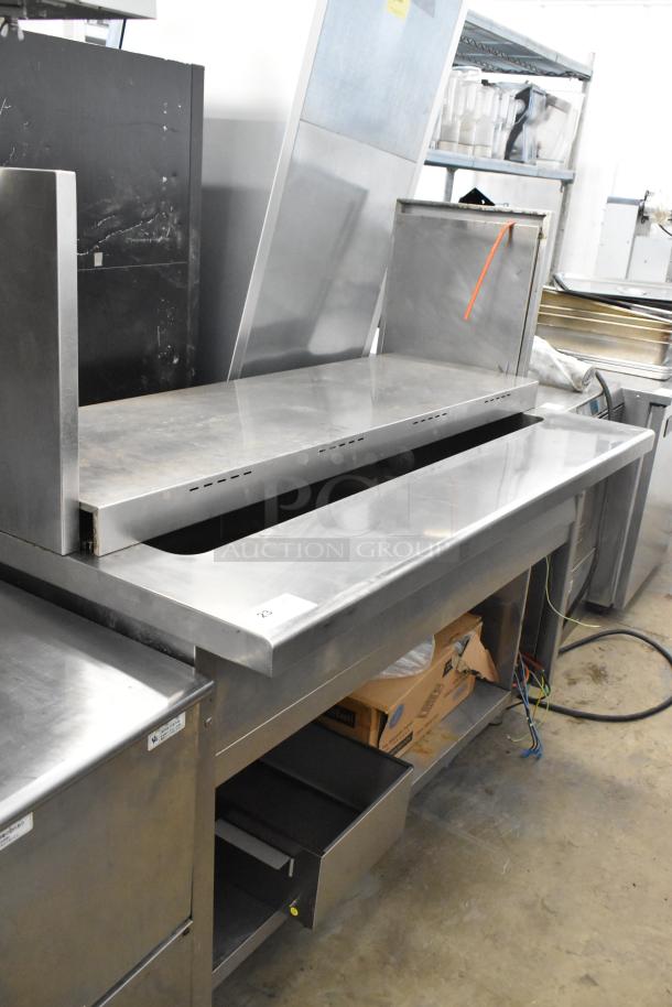 Stainless steel commercial steam table with two tiers, showing some wear. Suitable for food service operations.