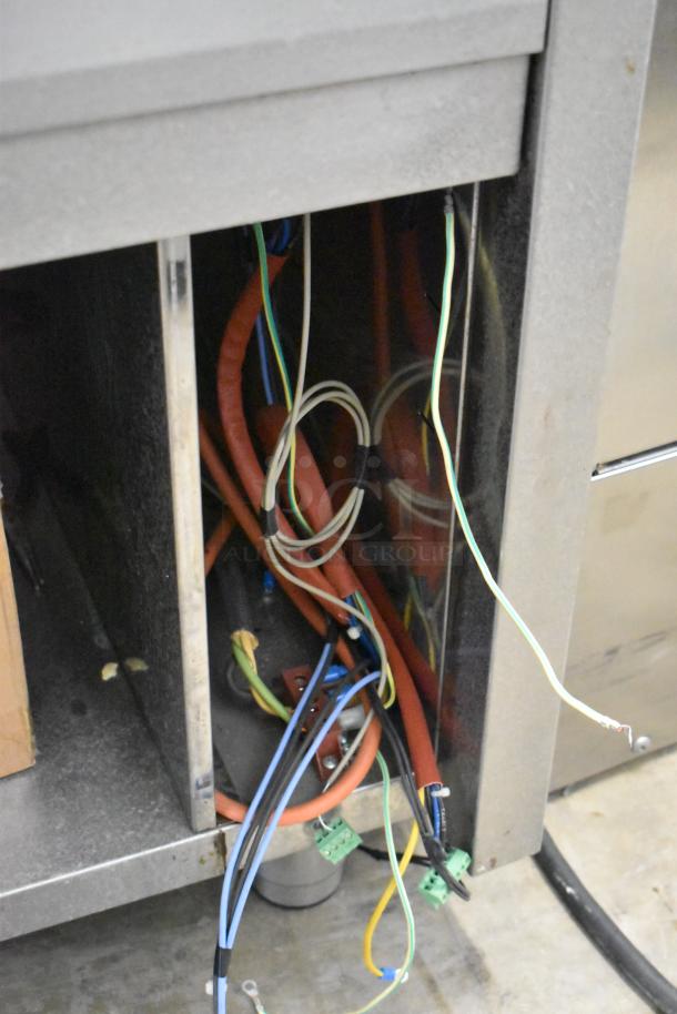 Stainless steel commercial steam table with exposed wiring. Features durable construction, suitable for professional kitchens.