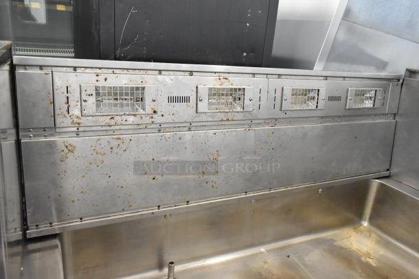 Stainless steel commercial steam table with visible rust spots and mild wear. Ventilated panels on upper section.