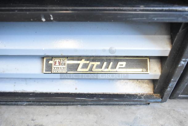 True GDM-12 commercial cooler label, showing model and brand logo. Durable metal design, single door, poly coated racks.