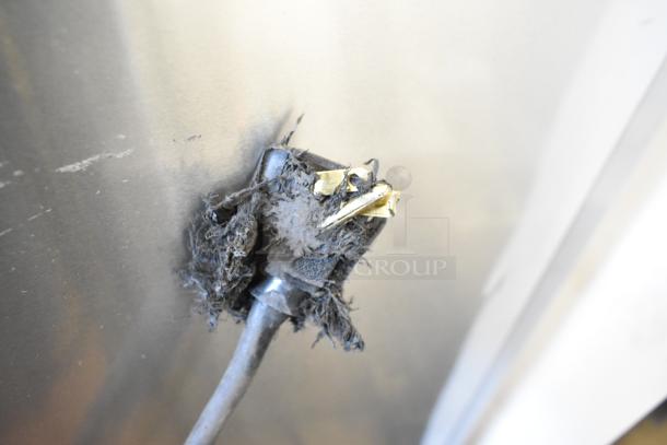 True T-35 reach-in cooler showing damaged power plug, surrounded by dust and debris. Needs cleaning and repair.