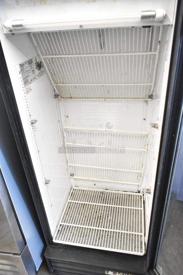 True GDM-12 single door cooler, metal construction, 115V. Interior shows wear. Model and voltage label visible inside.