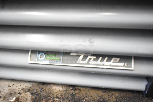 2020 True GDM-12-HC commercial cooler; metal, single door needs reattachment; 115V, 1 phase; "natural refrigerant" label.