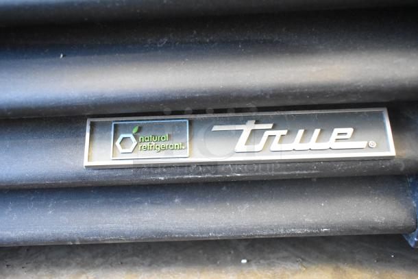 True GDM-26F-HC label, featuring "natural refrigerant" text, on black surface of commercial freezer.