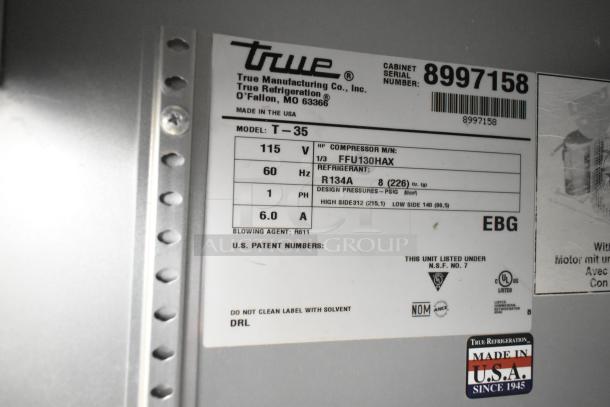 Label on True T-35 cooler shows model, 115V, 1-phase details, and refrigerant type R134A. Made in the USA. Serial number displayed.