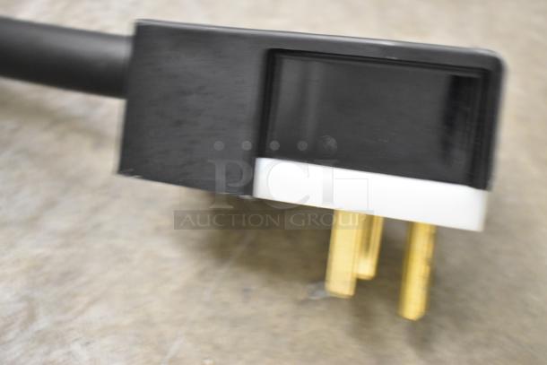 Close-up of a black and white power plug with gold prongs for a Garland MCO-E-5-C convection oven.