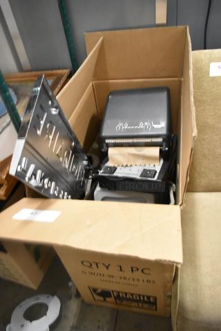 Cardboard box with paper towel dispenser, keyboard, and trash can. Box labeled "QTY 1 PC, Made in China, Fragile."