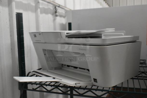 HP DeskJet Plus 4155 printer on a wire shelf, in good condition, with model label visible.