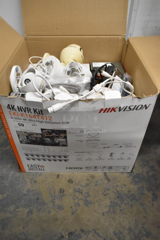 Hikvision 4K NVR Security Camera Kit in box, includes multiple cameras, cables, and components. Model EKI-K164T412.