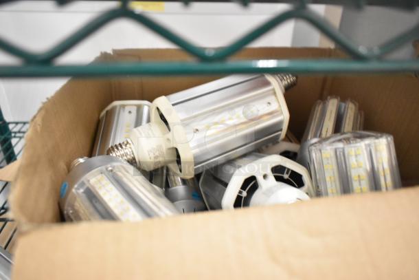 Box of Philips LED lightbulbs, assorted styles, gently used condition, visible technical markings on bases.
