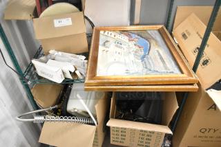 Two-tier shelving with various items including Delco dinner knives, framed painting, and boxes; mixed lot auction.