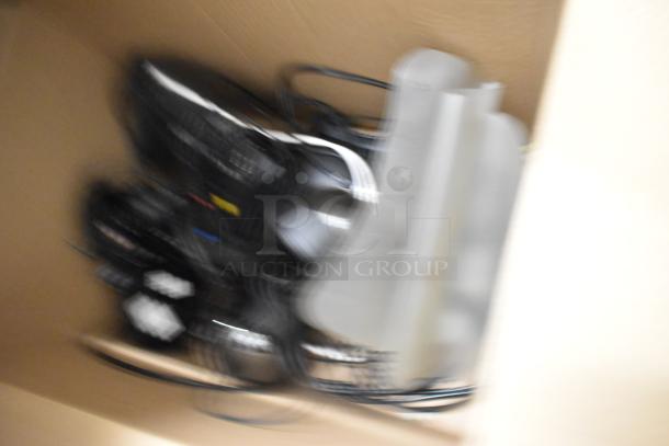 Blurry image of a mixed lot including cables, a box, and indiscernible items. Auction item: Two Tier Lot with framed pictures, dinner knives.