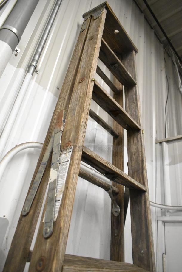 Werner W3910 10' wooden A-frame ladder, worn condition, visible metal supports and safety label on side.