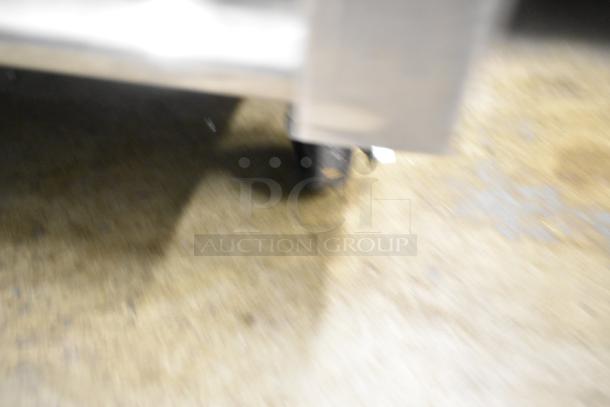 Blurry image of a True T-23F-HC freezer on commercial casters, highlighting its mobility feature.