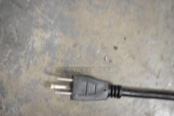 Close-up of a power plug for the Carnival King JETCOF 480M beverage dispenser on a concrete floor.