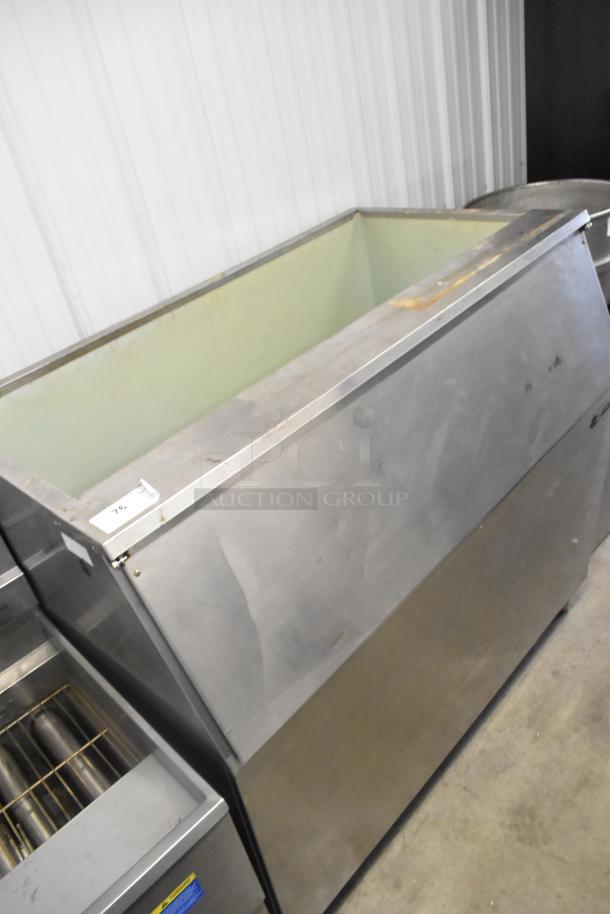 Follett metal commercial ice bin in used condition, showing stainless steel exterior with some wear and tear.
