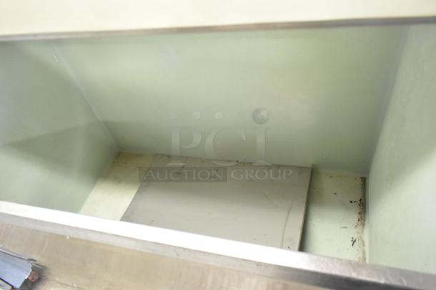 Follett metal commercial ice bin, interior view showing spacious compartment. Visible signs of wear and some residue.