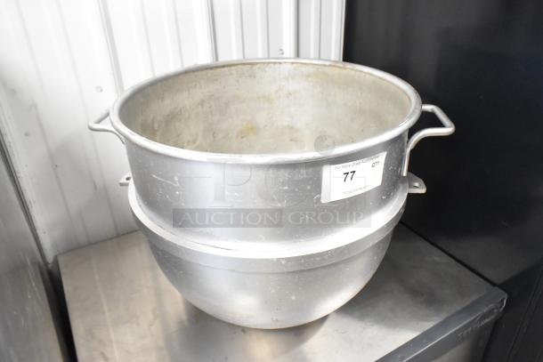 Stainless steel mixing bowl with side handles, moderate wear, auction label marked "77".