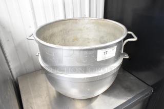 Stainless steel mixing bowl with side handles, moderate wear, auction label marked "77".